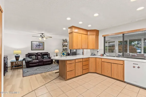 a large white kitchen with cabinets a sink and a window