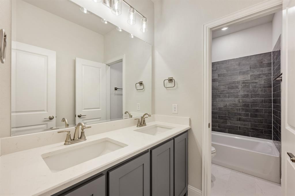 204 Sweetwater Drive Commerce, TX 75428 - Photo 12 of 38 a bathroom with a sink double vanity and a bathtub