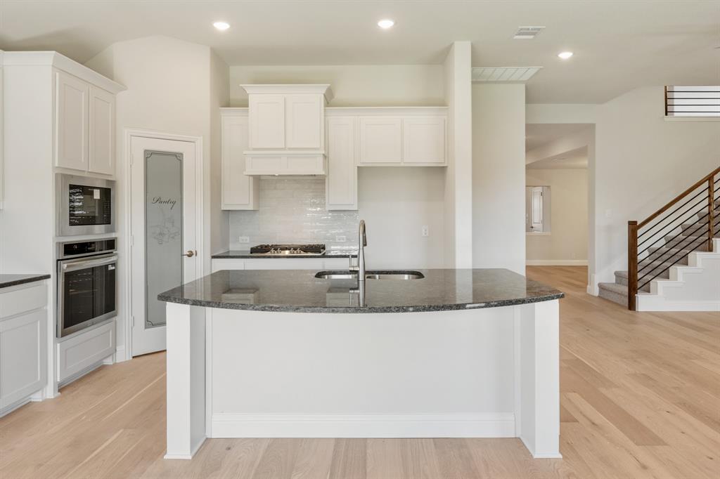 204 Sweetwater Drive Commerce, TX 75428 - Photo 18 of 38 a large kitchen with granite countertop a large counter top stainless steel appliances and cabinets