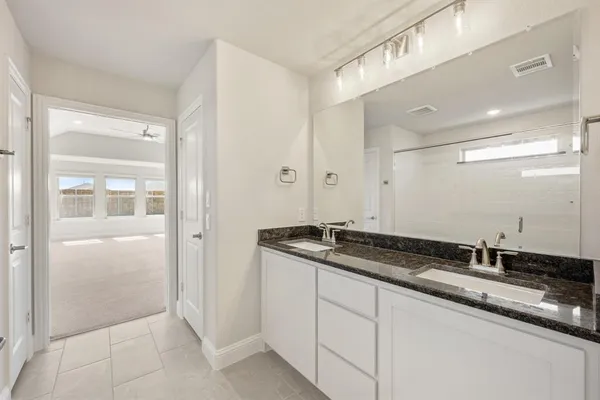 a bathroom with a granite countertop sink and a mirror