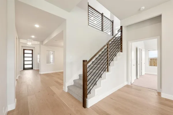 a view of a hallway with wooden floor and stairs