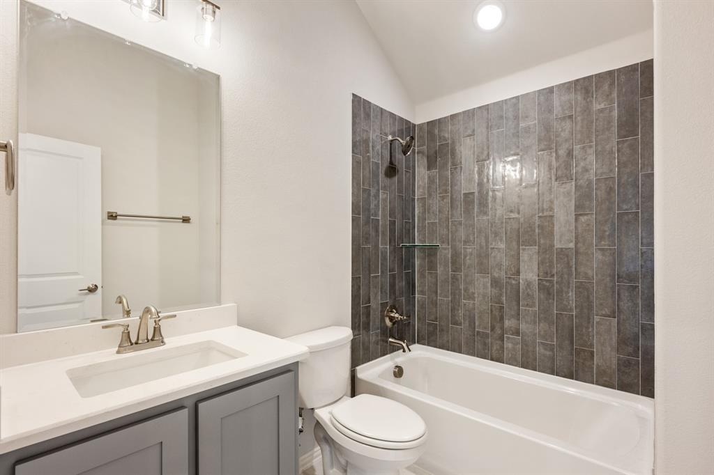 204 Sweetwater Drive Commerce, TX 75428 - Photo 34 of 38 a bathroom with a bathtub shower sink vanity mirror and toilet