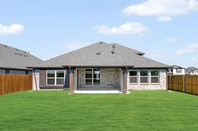 a view of a big house with a big yard and large trees