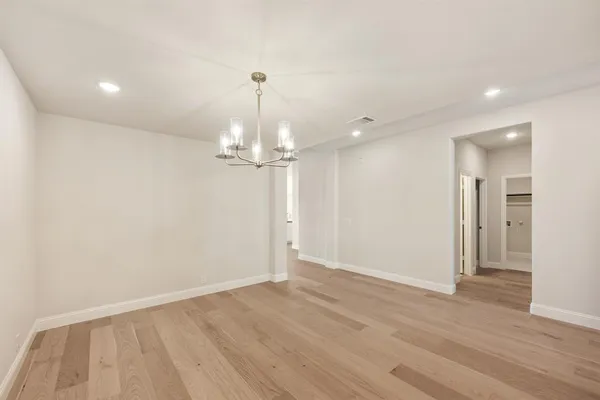 a view of empty room with wooden floor and ceiling fan