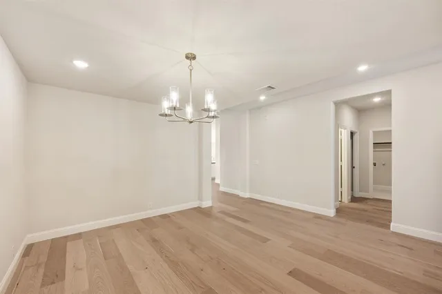 a view of empty room with wooden floor and ceiling fan