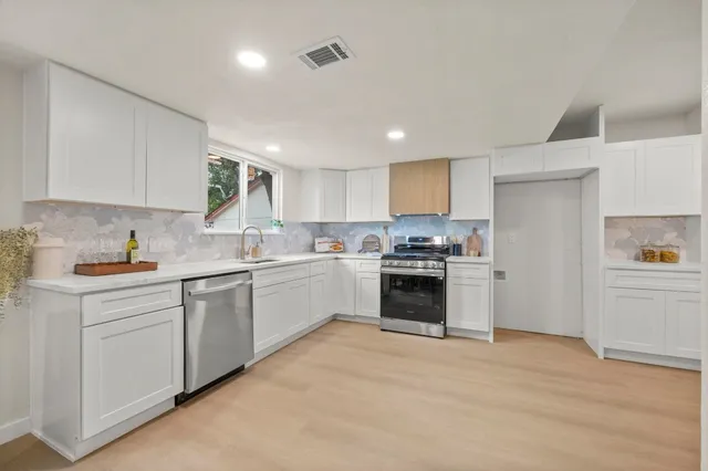 a kitchen with granite countertop white cabinets and white appliances