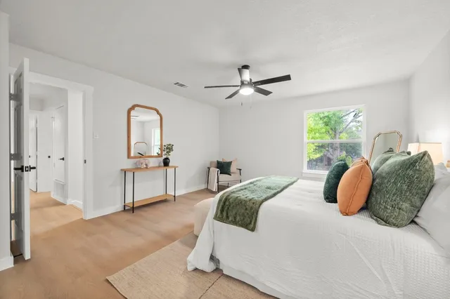 a bedroom with a large bed and a chandelier