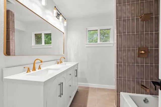 a bathroom with a double vanity sink a mirror and a shower