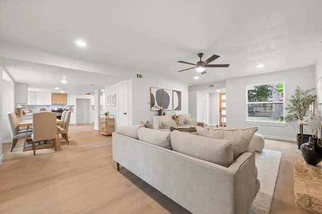 a living room with furniture and a large window with wooden floor