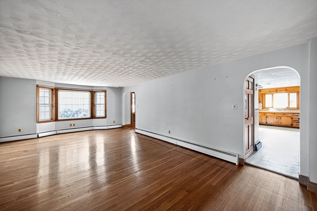 77 Whipple Road Billerica, MA 01821 - Photo 11 of 30 an empty room with wooden floor and windows