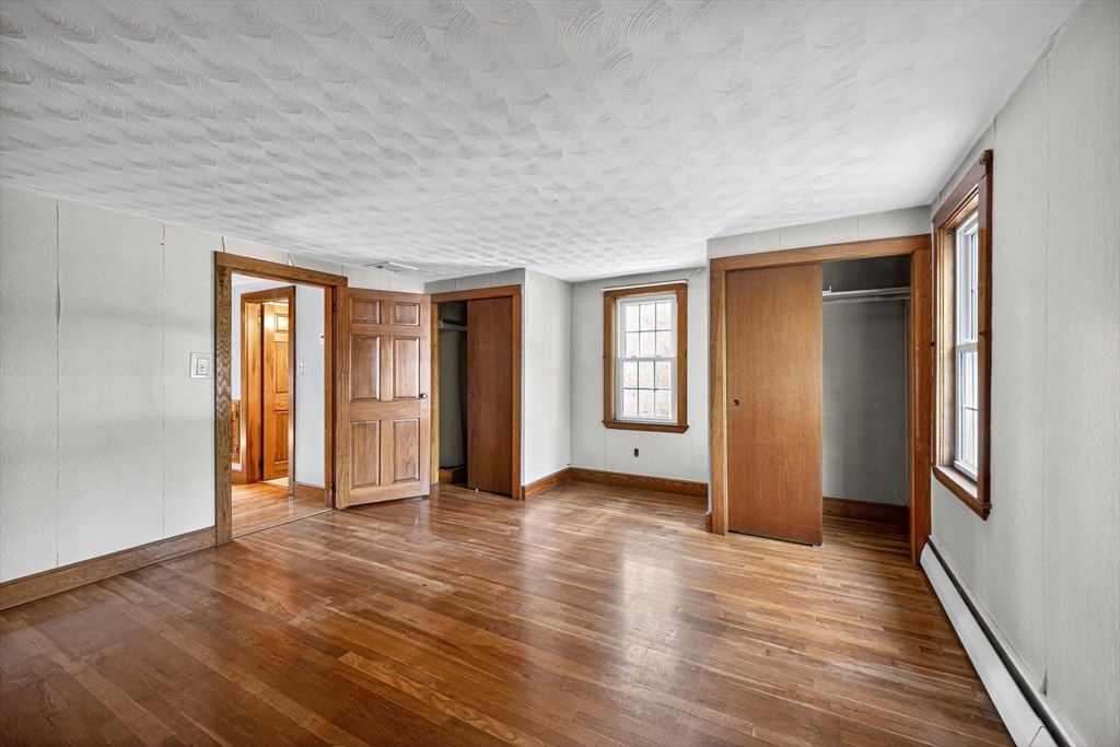 77 Whipple Road Billerica, MA 01821 - Photo 17 of 30 a view of an empty room with window and wooden floor