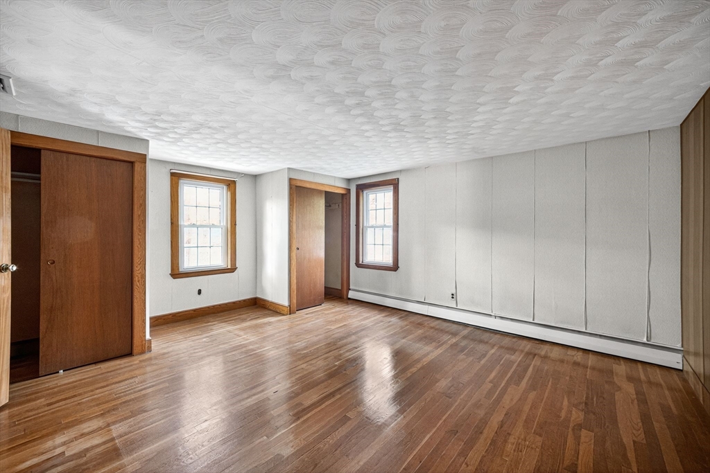 77 Whipple Road Billerica, MA 01821 - Photo 23 of 30 a view of an empty room with wooden floor and a window