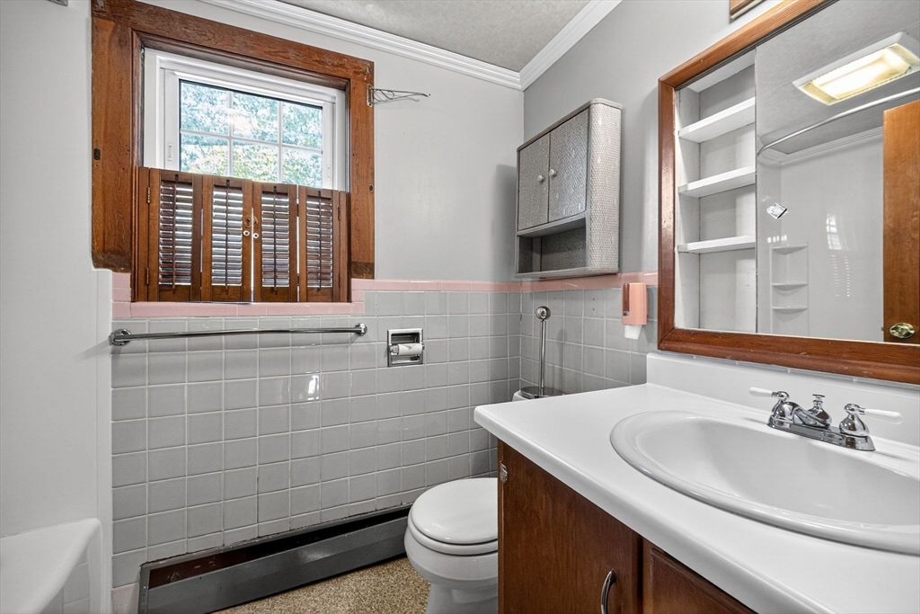 77 Whipple Road Billerica, MA 01821 - Photo 24 of 30 a bathroom with a sink a toilet a mirror and a window