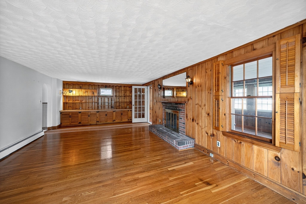 77 Whipple Road Billerica, MA 01821 - Photo 8 of 30 a view of an empty room with wooden floor and a window