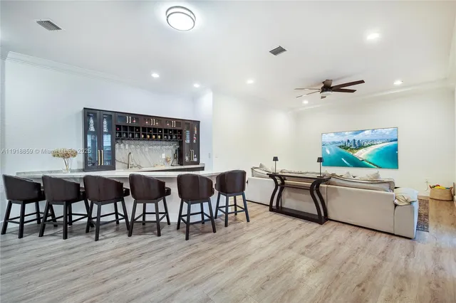 a kitchen with stainless steel appliances kitchen island granite countertop a sink dishwasher a stove and a refrigerator with wooden floor