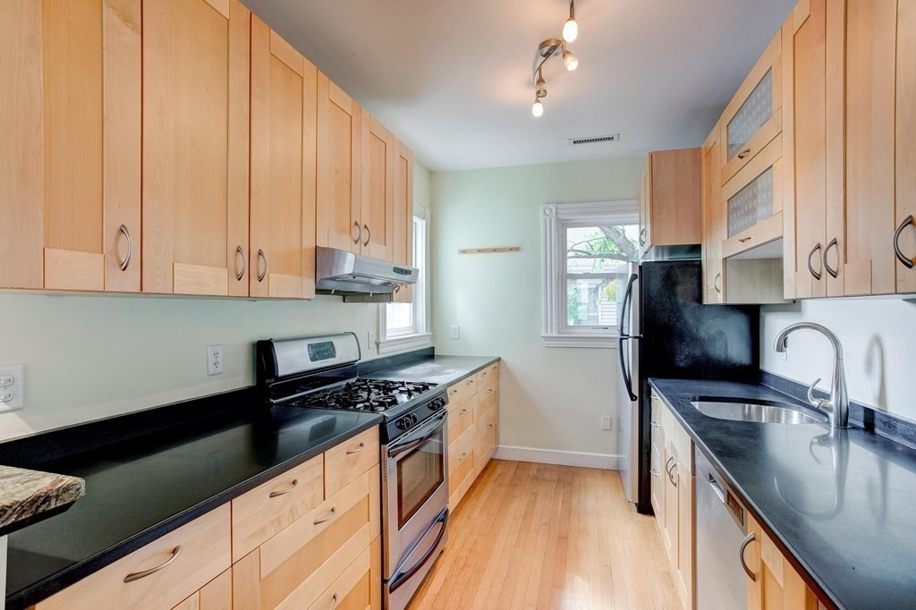 59 Creighton Street, Unit 2 Cambridge, MA 02140 - Photo 14 of 38 a kitchen with granite countertop a sink cabinets and stainless steel appliances