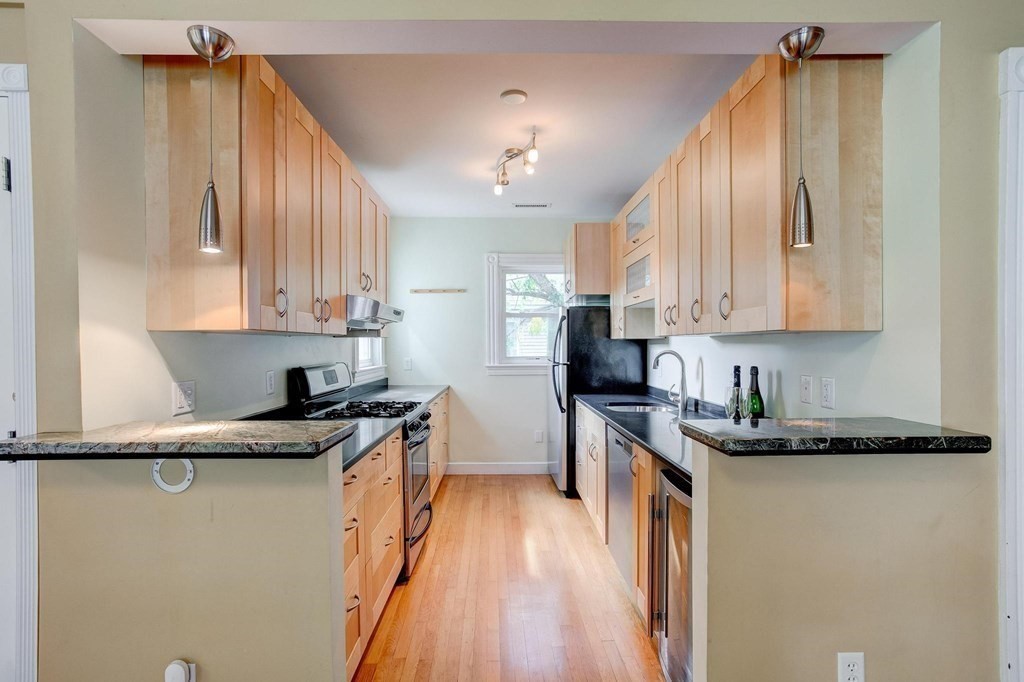 59 Creighton Street, Unit 2 Cambridge, MA 02140 - Photo 16 of 38 a kitchen with stainless steel appliances granite countertop a sink stove and refrigerator