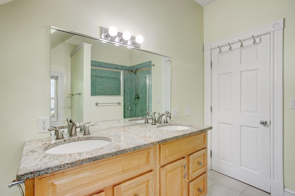 59 Creighton Street, Unit 2 Cambridge, MA 02140 - Photo 18 of 38 a bathroom with a granite countertop sink and a mirror