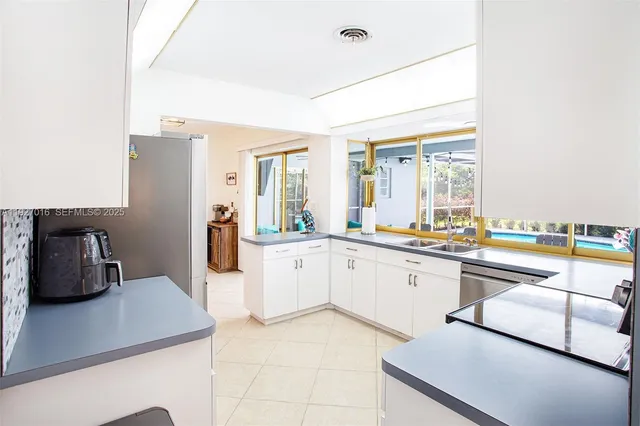 a kitchen with white cabinets and stainless steel appliances