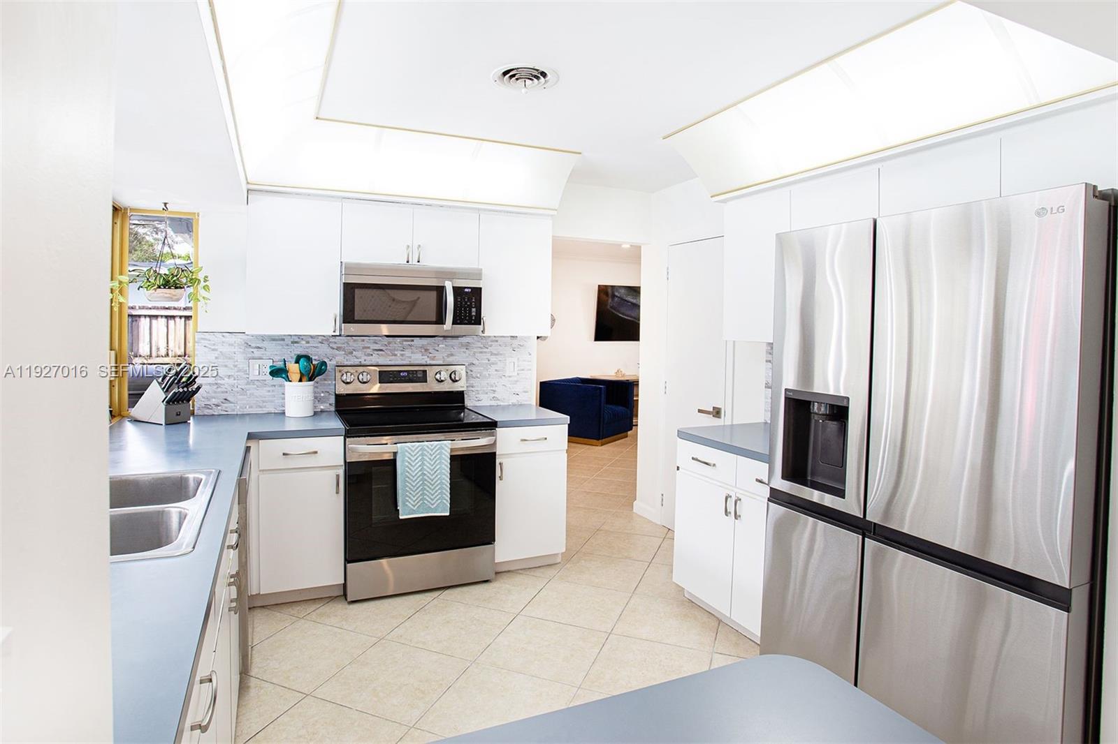 4316 Jackson Street Hollywood, FL 33021 - Photo 17 of 31 a kitchen with white cabinets and stainless steel appliances