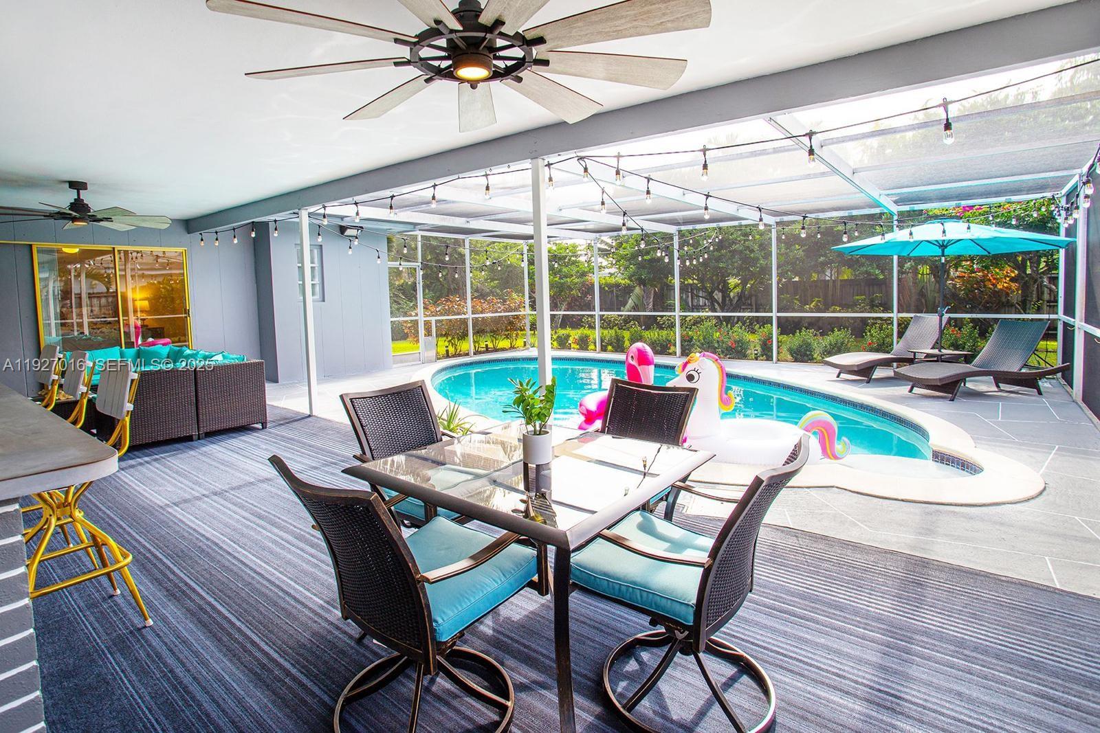4316 Jackson Street Hollywood, FL 33021 - Photo 27 of 31 a dining room with furniture wooden floor and a chandelier