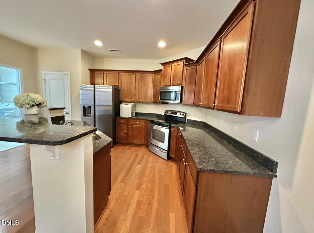 1345 Still Monument Way Raleigh, NC 27603 - Photo 5 of 21 a kitchen with stainless steel appliances granite countertop a sink stove and refrigerator
