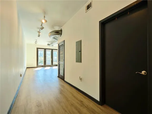 a view of a hallway with wooden floor and stairs