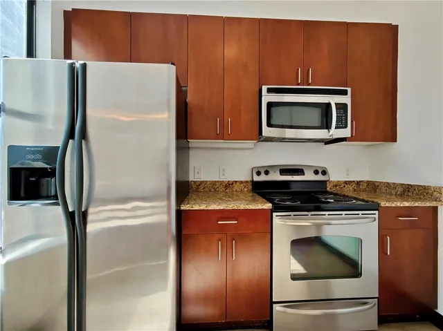 a kitchen with stainless steel appliances granite countertop a refrigerator and a stove