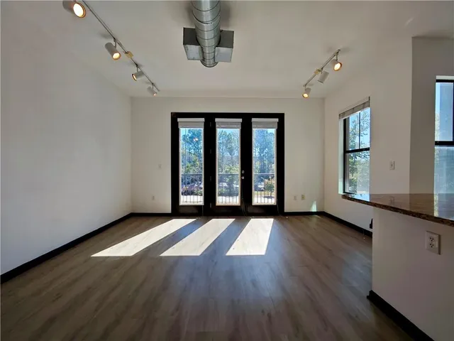 an empty room with wooden floor and windows