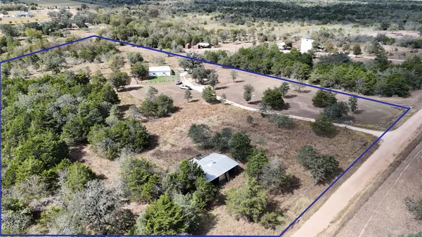 an aerial view of a house with a yard and lake view