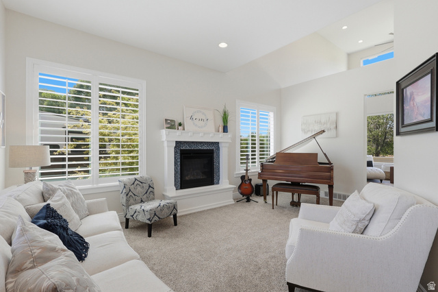 10676 Urban Rdg Cove South Jordan, UT 84095 - Photo 4 of 48 Spacious room featuring vaulted ceilings, a fireplace with a decorative tile surround and white mantle, and multiple windows with plantation shutters