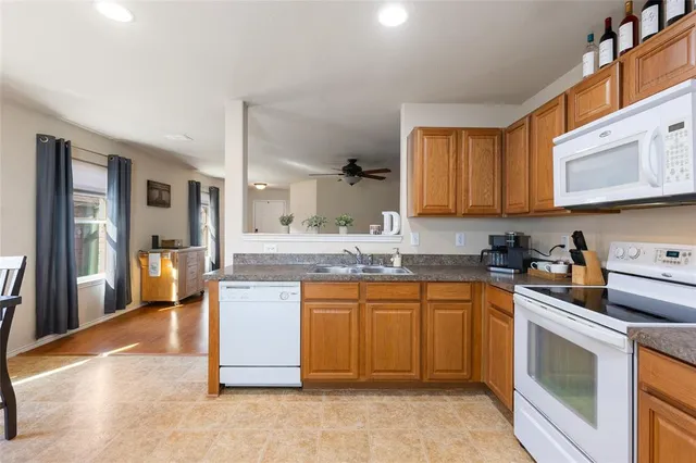 a kitchen with stainless steel appliances granite countertop a stove a sink dishwasher and a refrigerator