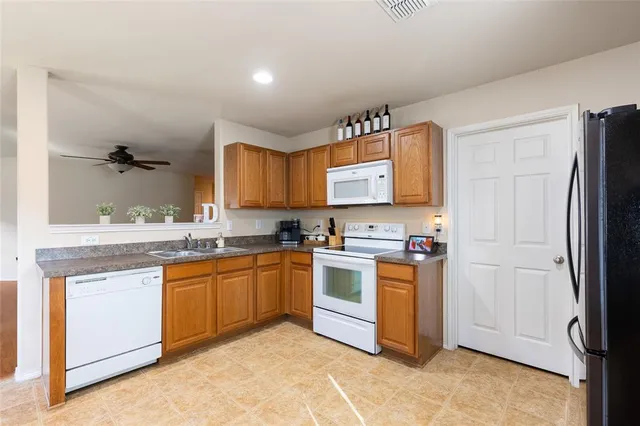 a kitchen with stainless steel appliances granite countertop a stove a sink dishwasher and a refrigerator