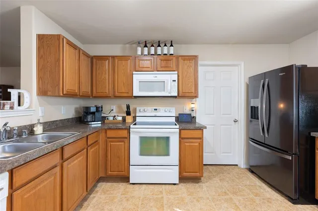 a kitchen with stainless steel appliances granite countertop a refrigerator stove and sink