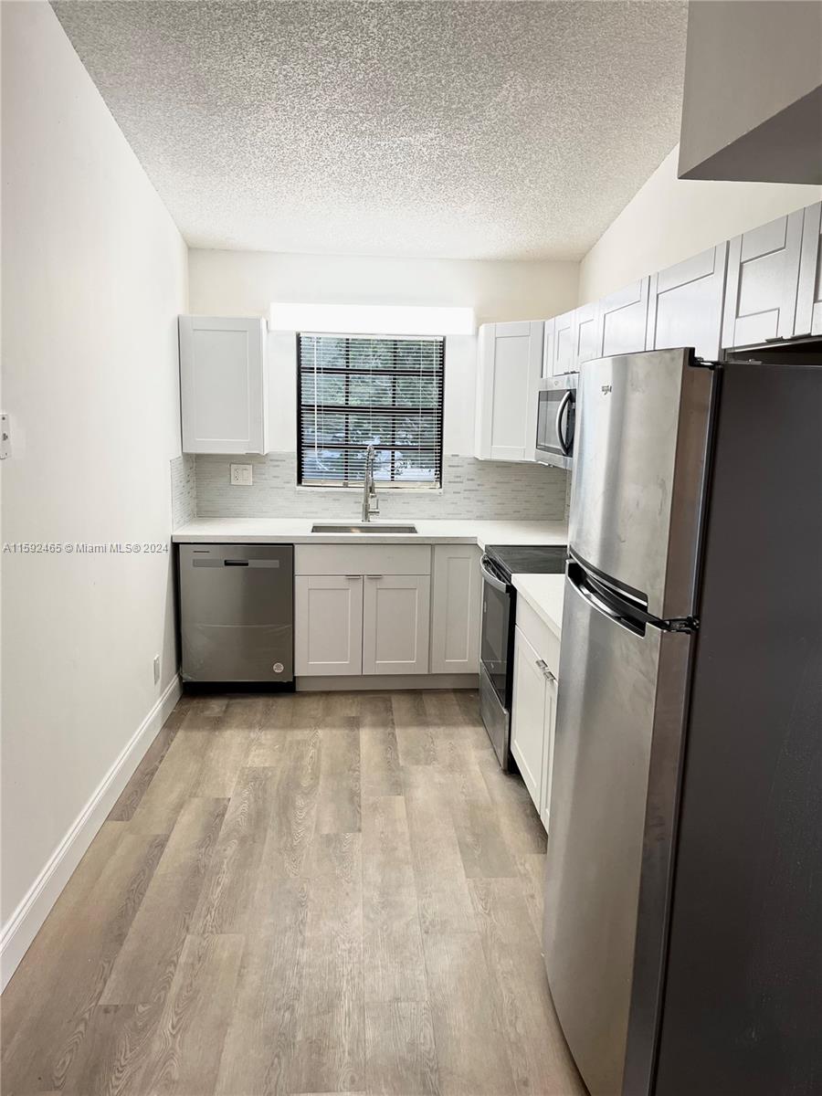 301 Olivewood Place, Unit O229 Boca Raton, FL 33431 - Photo 2 of 25 a kitchen with stainless steel appliances a refrigerator sink and cabinets