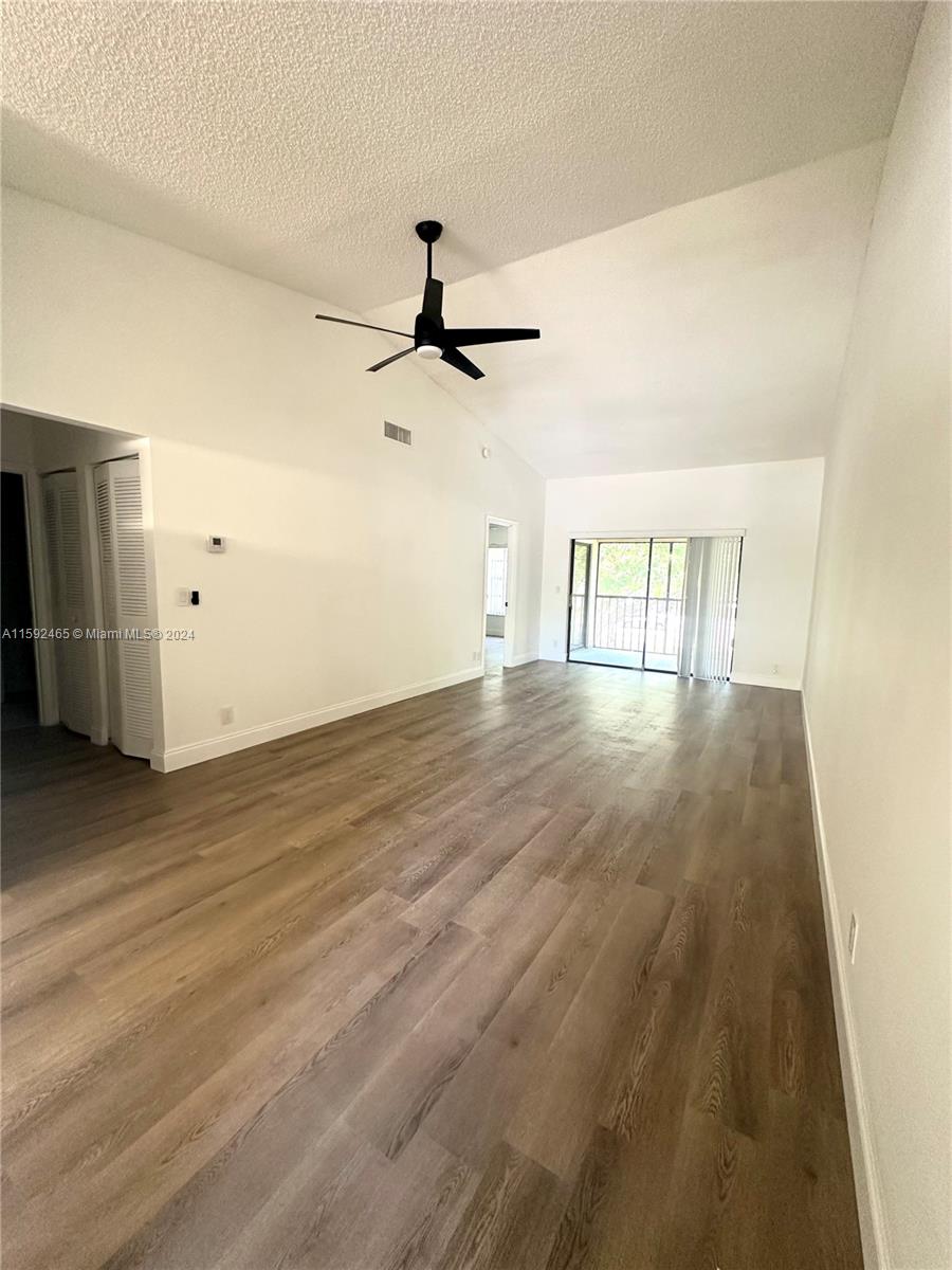 301 Olivewood Place, Unit O229 Boca Raton, FL 33431 - Photo 3 of 25 a view of an empty room with wooden floor and a ceiling fan