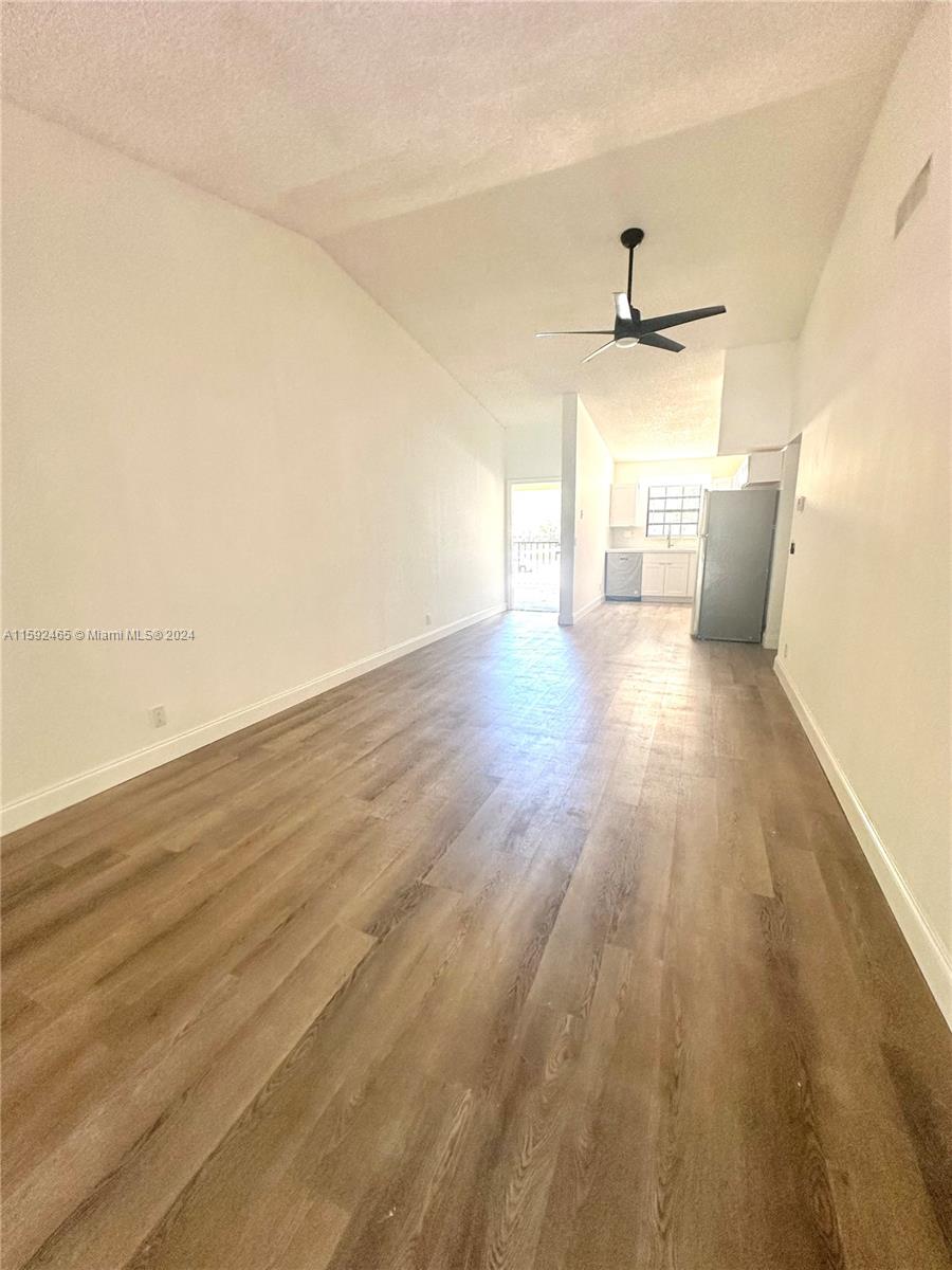 301 Olivewood Place, Unit O229 Boca Raton, FL 33431 - Photo 4 of 25 an empty room with wooden floor and windows