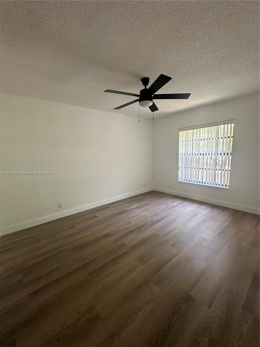 301 Olivewood Place, Unit O229 Boca Raton, FL 33431 - Photo 5 of 25 an empty room with wooden floor fan and windows