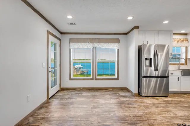 a view of kitchen with stainless steel appliances granite countertop a refrigerator and a sink