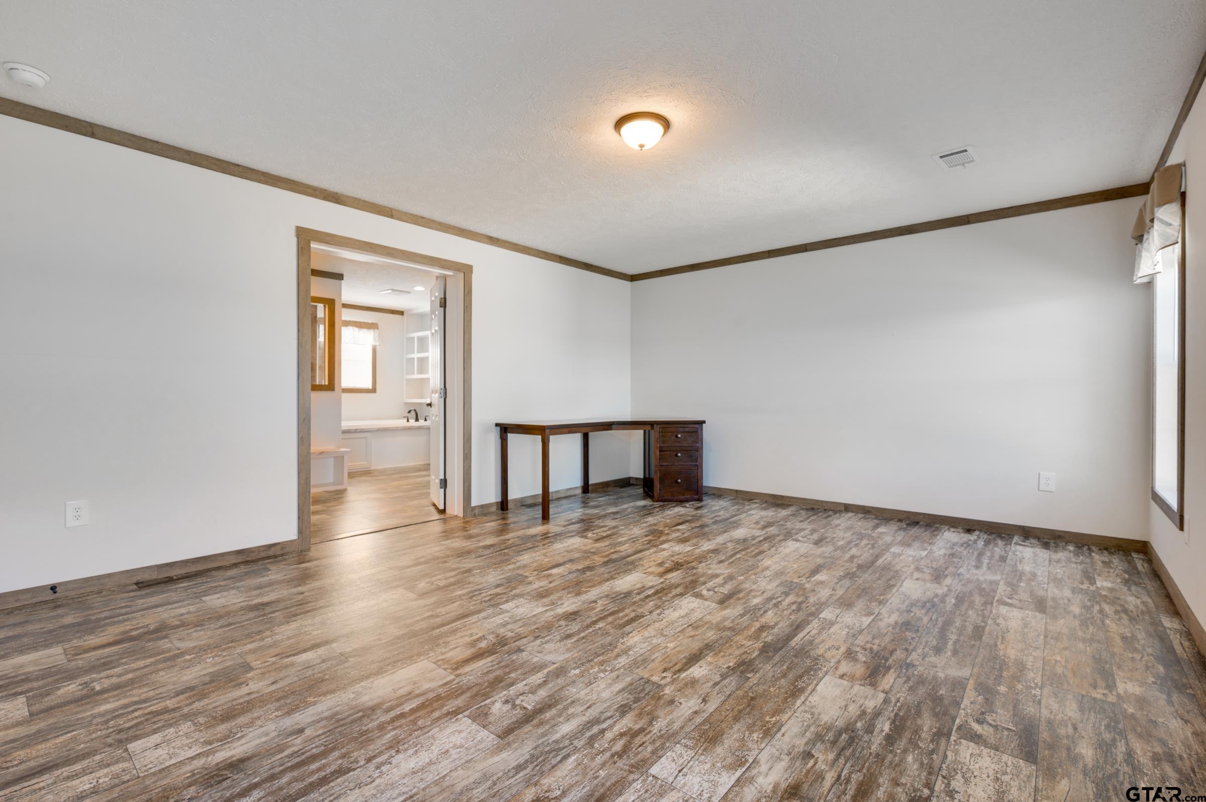 21903 Boles Road Frankston, TX 75763 - Photo 19 of 48 a view of an empty room with wooden floor and a window