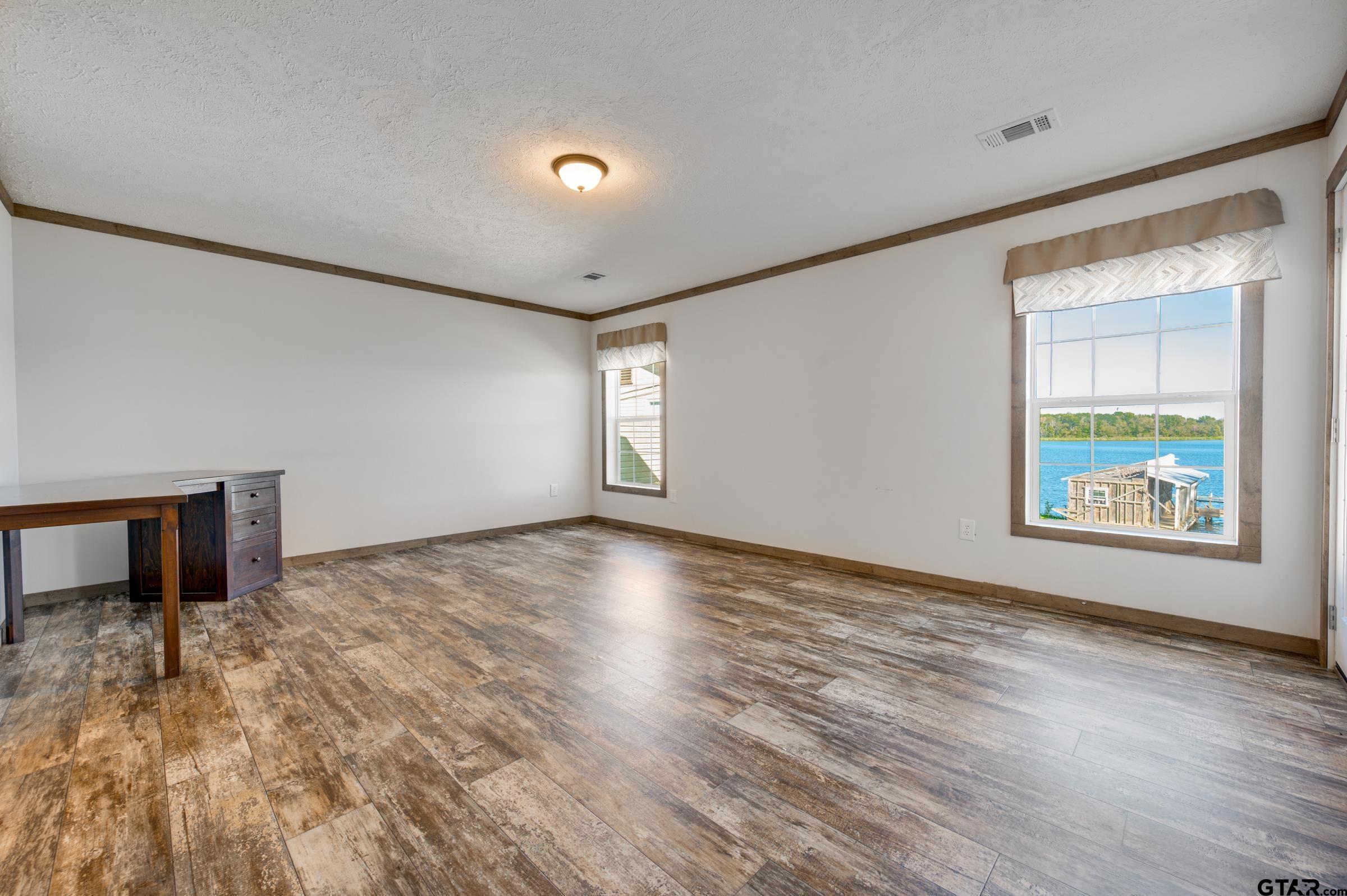 21903 Boles Road Frankston, TX 75763 - Photo 21 of 48 a view of an empty room with window and wooden floor
