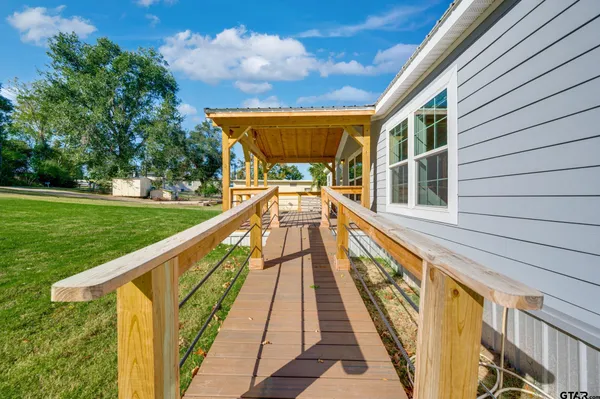 a large kitchen with stainless steel appliances granite countertop a stove a refrigerator a sink dishwasher and a large countertops with wooden floor