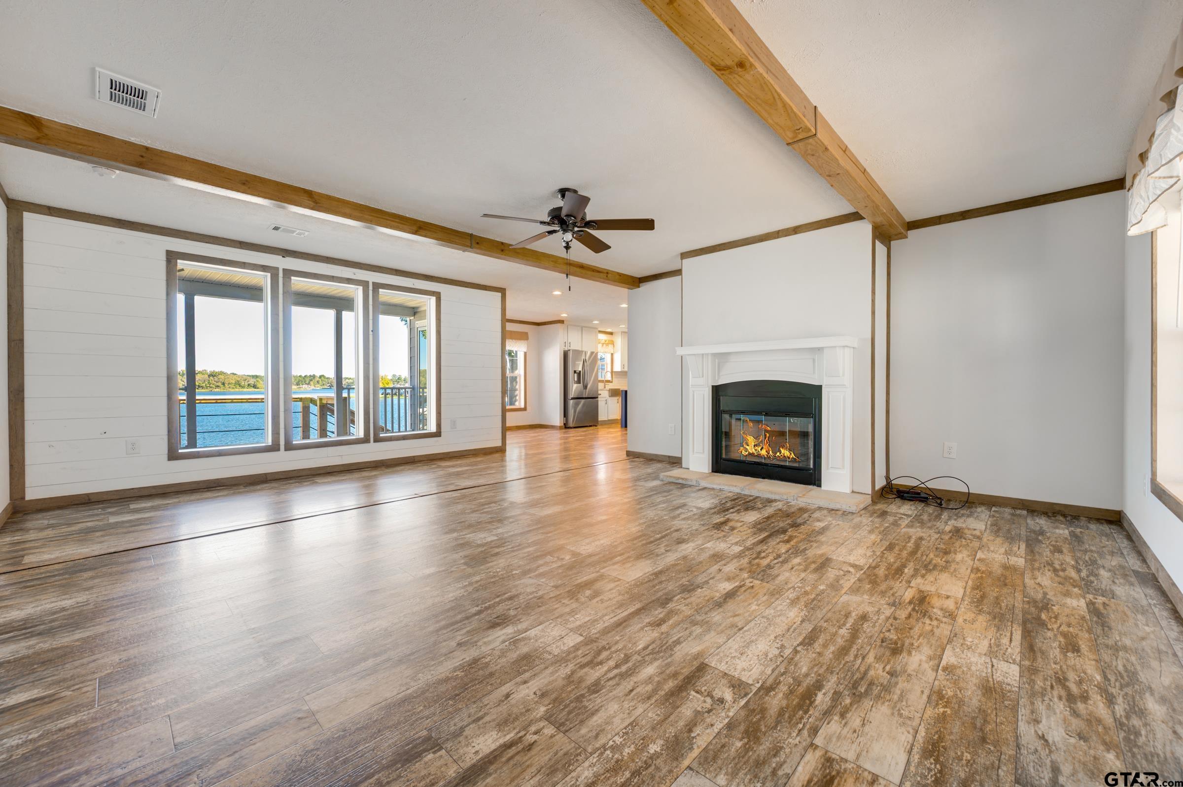 21903 Boles Road Frankston, TX 75763 - Photo 5 of 48 an empty room with wooden floor fireplace and windows