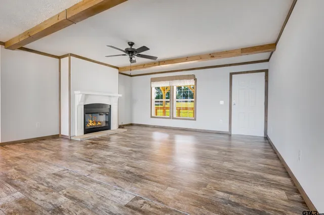 a view of empty room with a fireplace and fan
