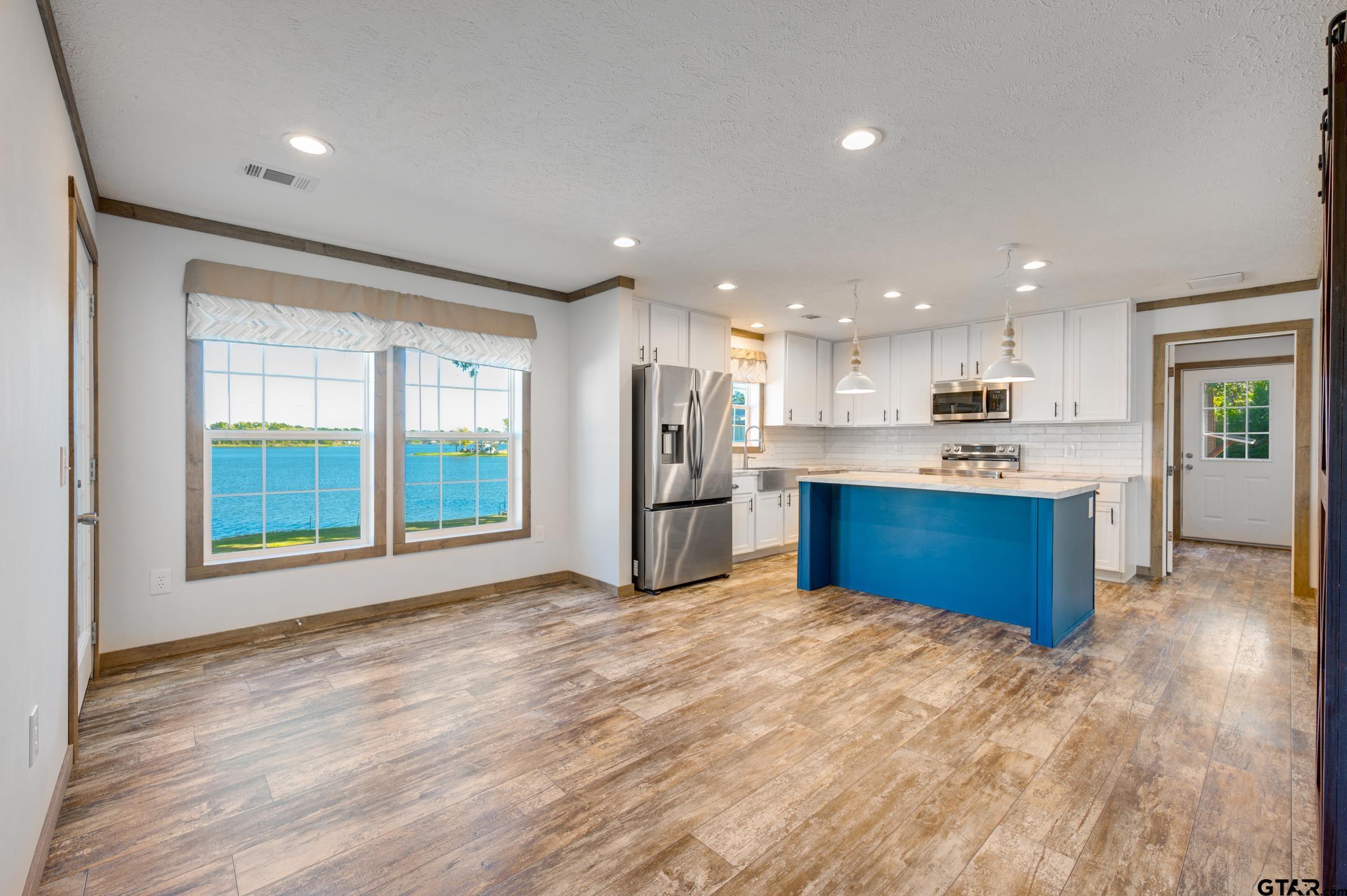 21903 Boles Road Frankston, TX 75763 - Photo 8 of 48 a large kitchen with stainless steel appliances granite countertop a stove a refrigerator a sink dishwasher and a large countertops with wooden floor