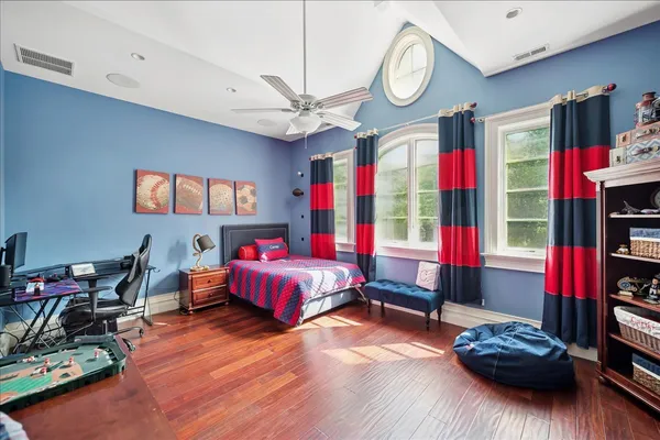 a bedroom with a bed a dresser and window