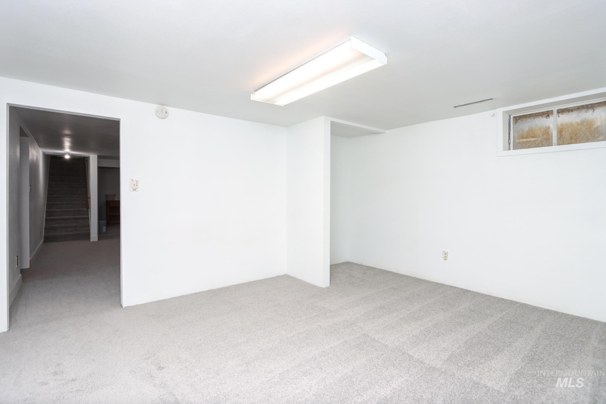 801 Thompson Avenue Nyssa, OR 97913 - Photo 27 of 46 Carpeted lower level room featuring white painted walls, a fluorescent ceiling light fixture, and a single window