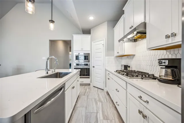 a kitchen with stainless steel appliances granite countertop a sink stove and cabinets