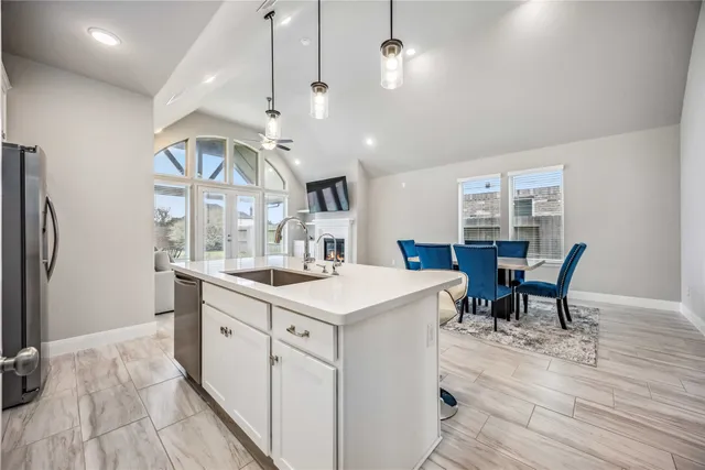 a kitchen with stainless steel appliances kitchen island granite countertop a table chairs and a refrigerator