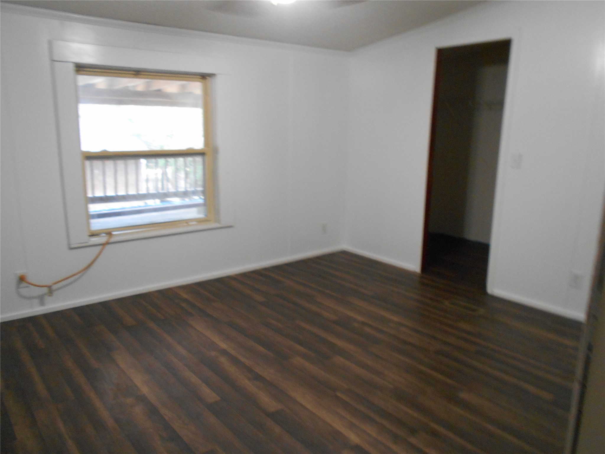 8001 Burleson Manor Road Manor, TX 78653 - Photo 10 of 31 Hardwood-style flooring and a bright window create an inviting atmosphere in this flexible space.
